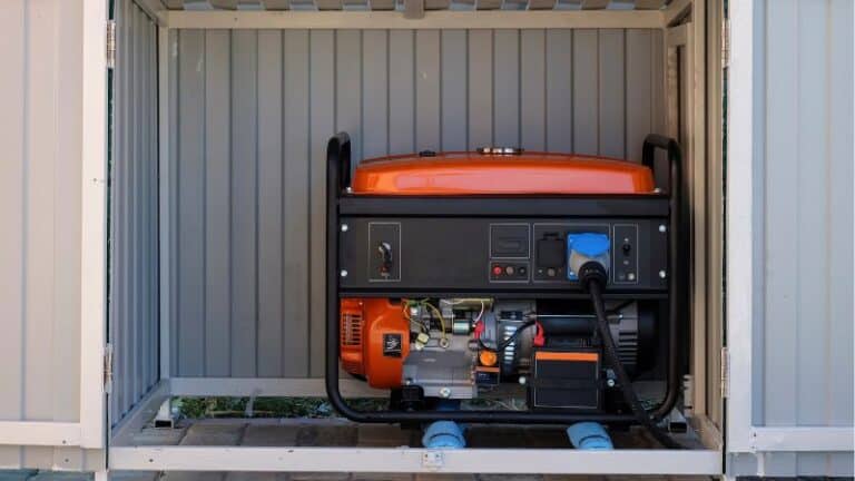 An orange portable generator is placed inside a small metal shed with open doors.