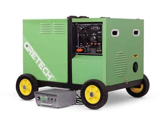 Generatore GRETECH verde con ruote gialle, collegato tramite cavo a una scatola di controllo grigia.