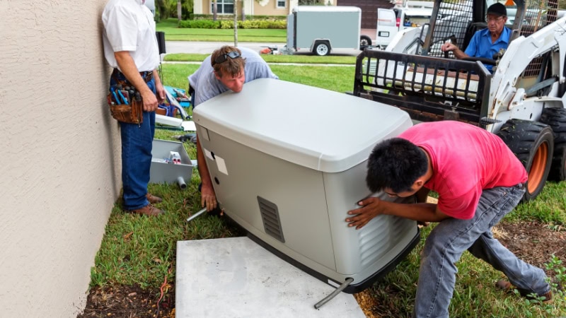 Generator installation in backyard with workers adjusting and securing the device for optimal performance. Ground level setup with tools and machinery nearby, ensuring a safe and efficient process.