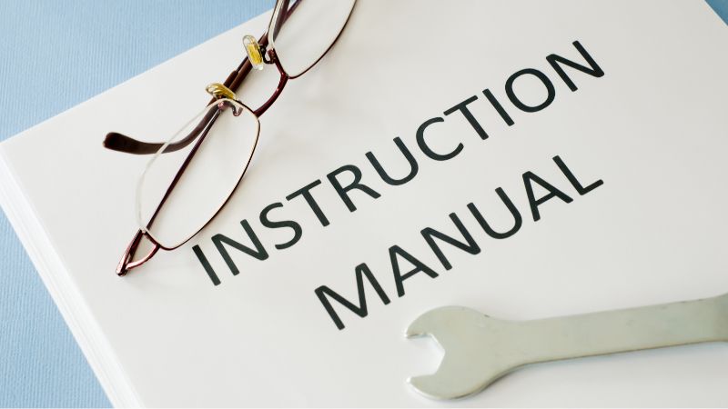 Een bril rust op een gebruiksaanwijzing met een moersleutel. De handleiding illustreert onderhouds- en reparatierichtlijnen voor doe-het-zelfprojecten.