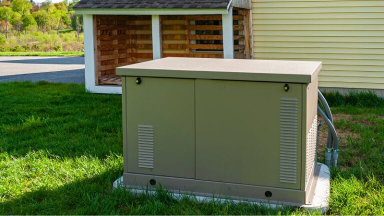 Generator outdoor air conditioning unit on a grassy lawn near a yellow house w/ a shed in background.
