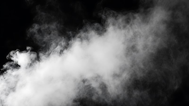 Dichter weißer Dampf oder Rauch vor schwarzem Hintergrund, der tiefe Reinigung oder Entspannung symbolisiert.
