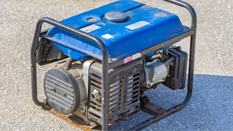 Portable blue generator on a concrete surface, ready for repair or maintenance, ideal for backup power solutions.